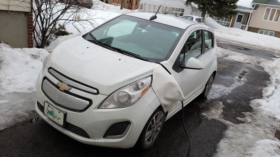 Voiture électrique en recharge sous la neige